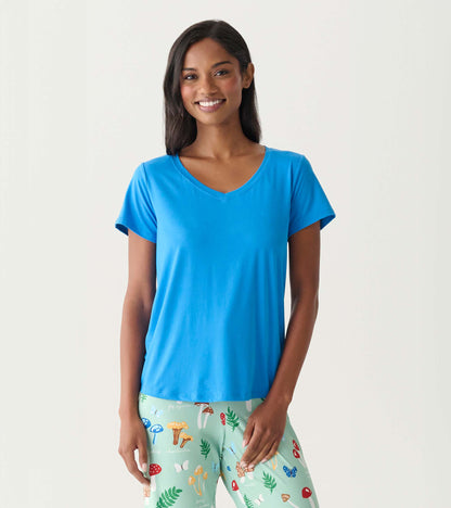 Woman wearing a bright blue V-neck short-sleeve T-shirt with mint green patterned pajama pants