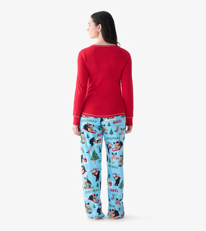 Back view of women's red long sleeve pajama top on model with blue holiday print pajama pants