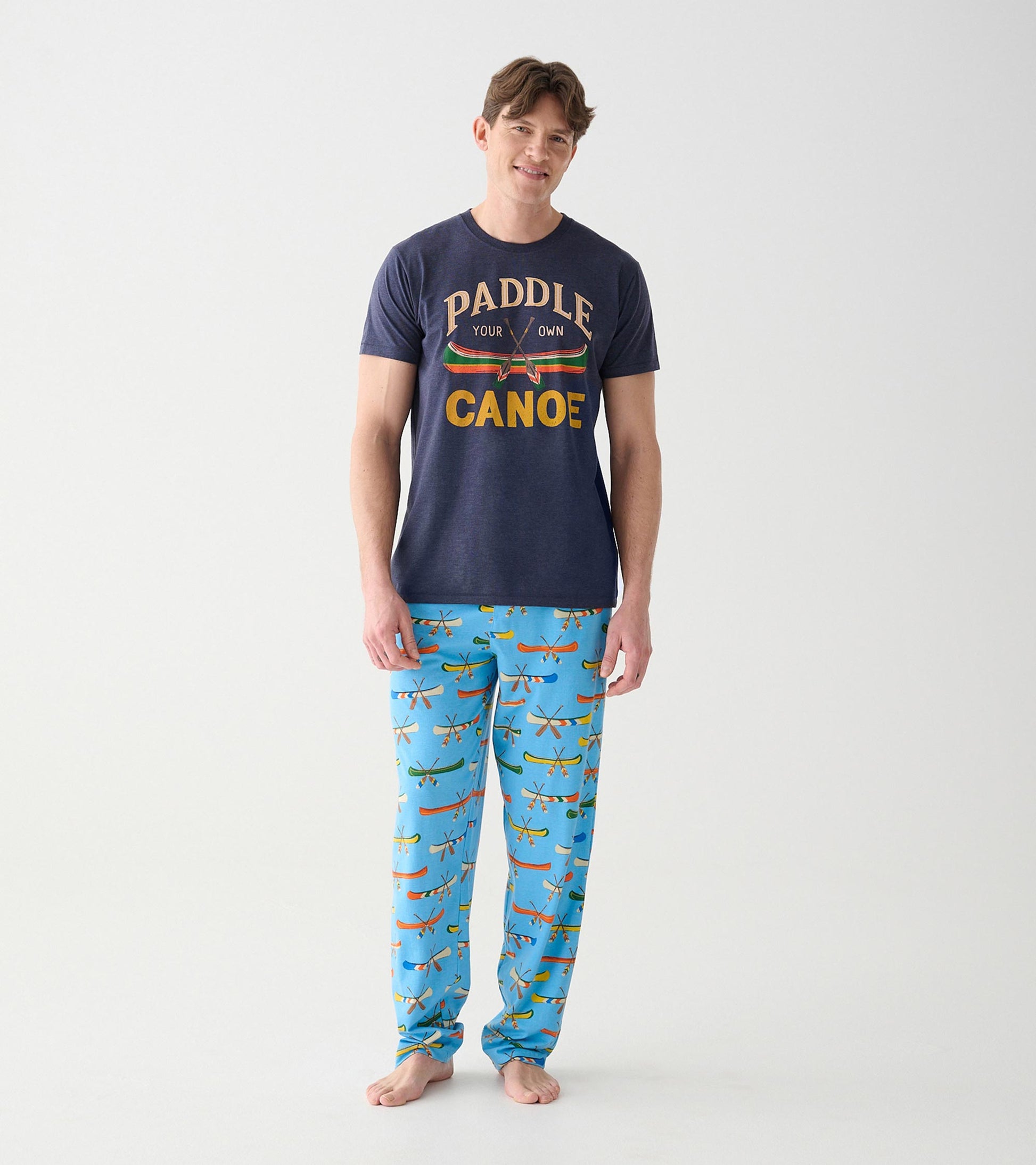 Navy Paddle Your Own Canoe tee on model with light blue pajama pants featuring canoe print
