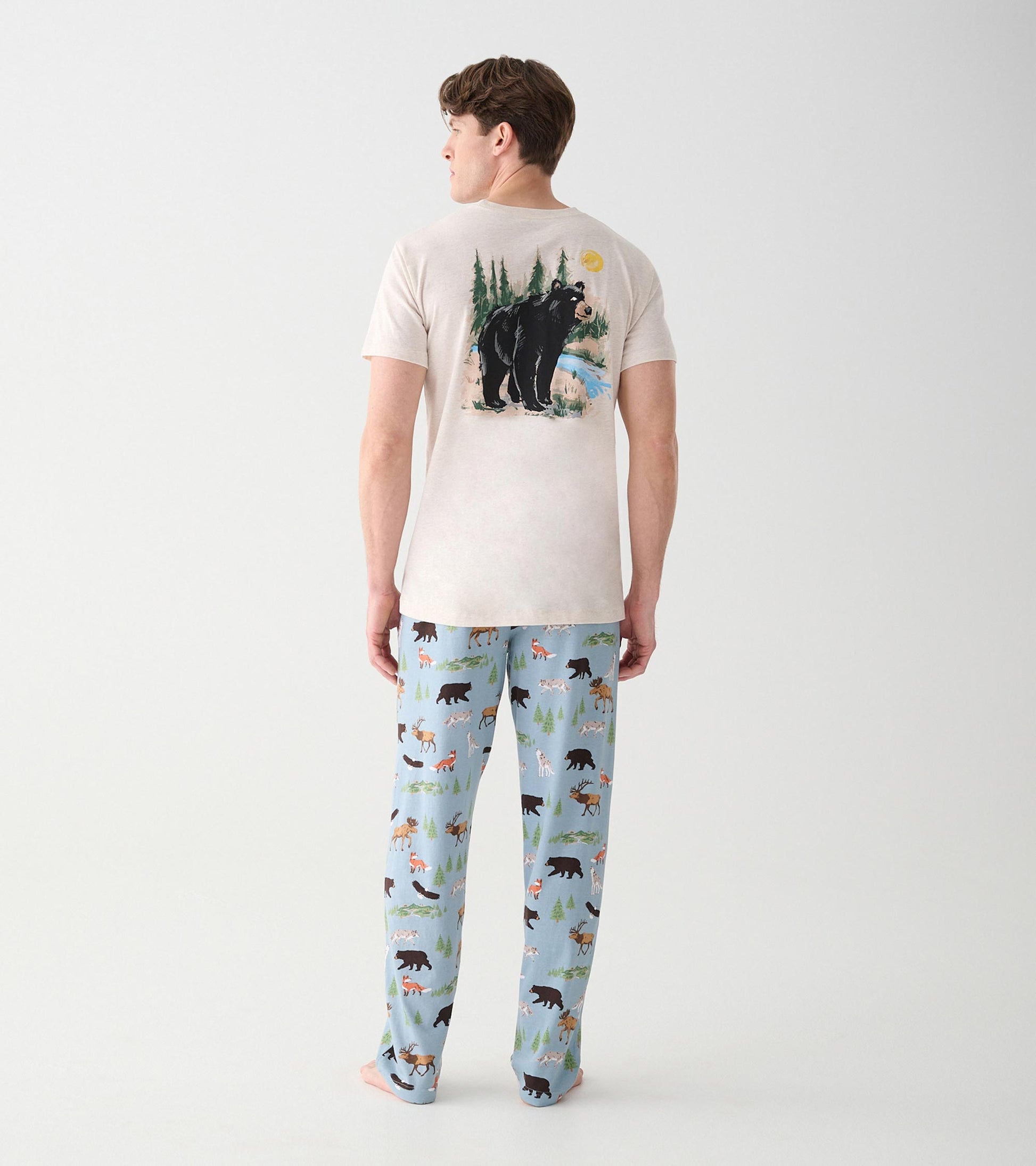 Full back view of oatmeal short sleeve T-shirt with wilderness bear scene graphic on model