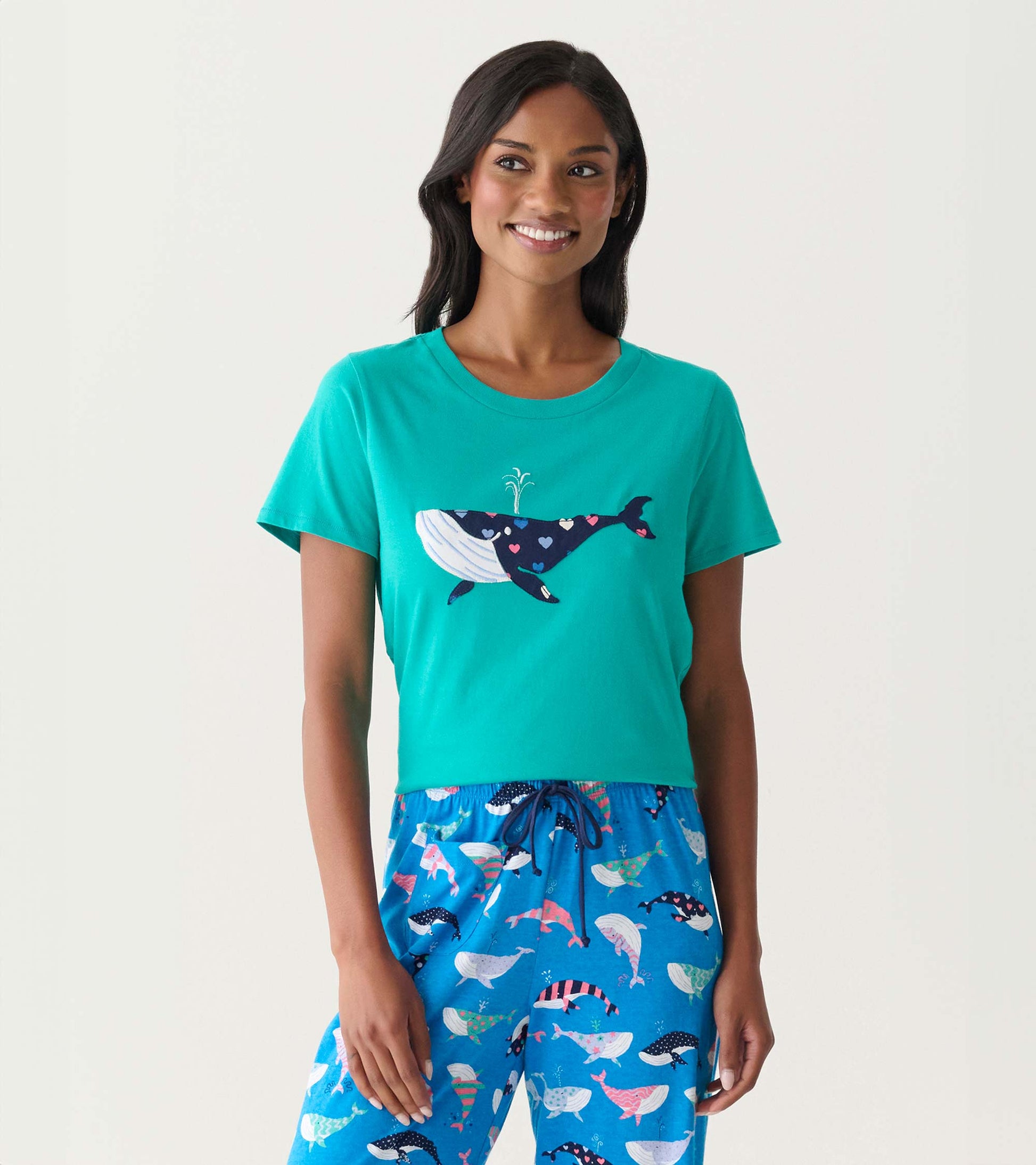 Teal short-sleeve pajama T-shirt with whale graphic, shown on model with matching whale-print pants.