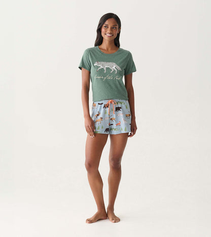 Green short-sleeve pajama T-shirt with wolf graphic and text, paired with light blue animal-print shorts on model