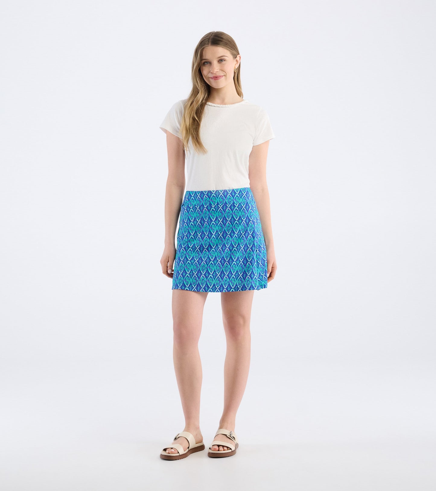 Blue skort featuring a diamond pattern, paired with a white top and sandals, shown from the front.
