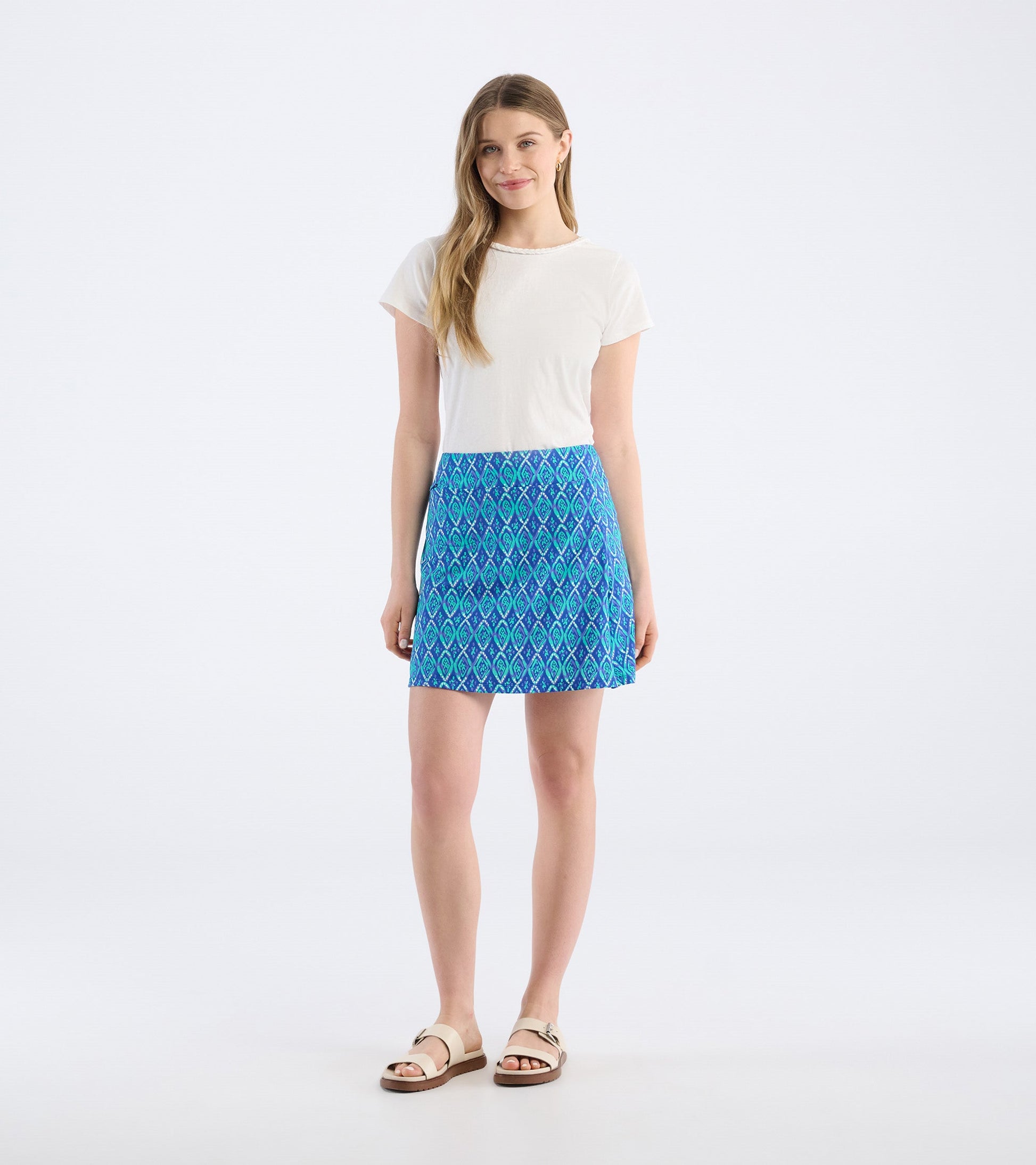 Blue skort featuring a diamond pattern, paired with a white top and sandals, shown from the front.