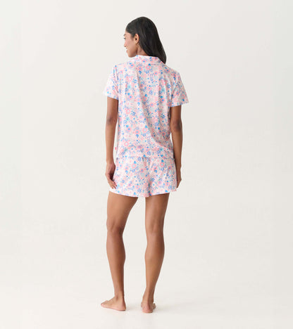 Back view of a pink and blue floral short-sleeve button-down pajama set with shorts