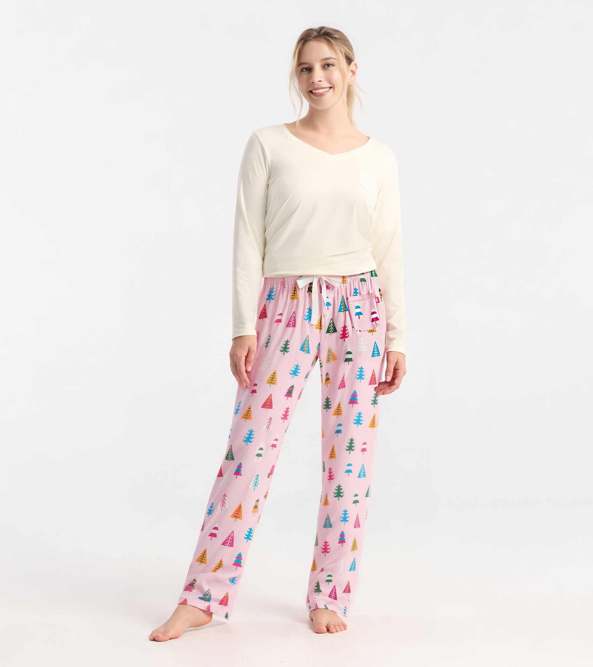 Pink pajama pants featuring colorful holiday tree patterns, made from soft polyknit material, with a comfortable elastic wai…