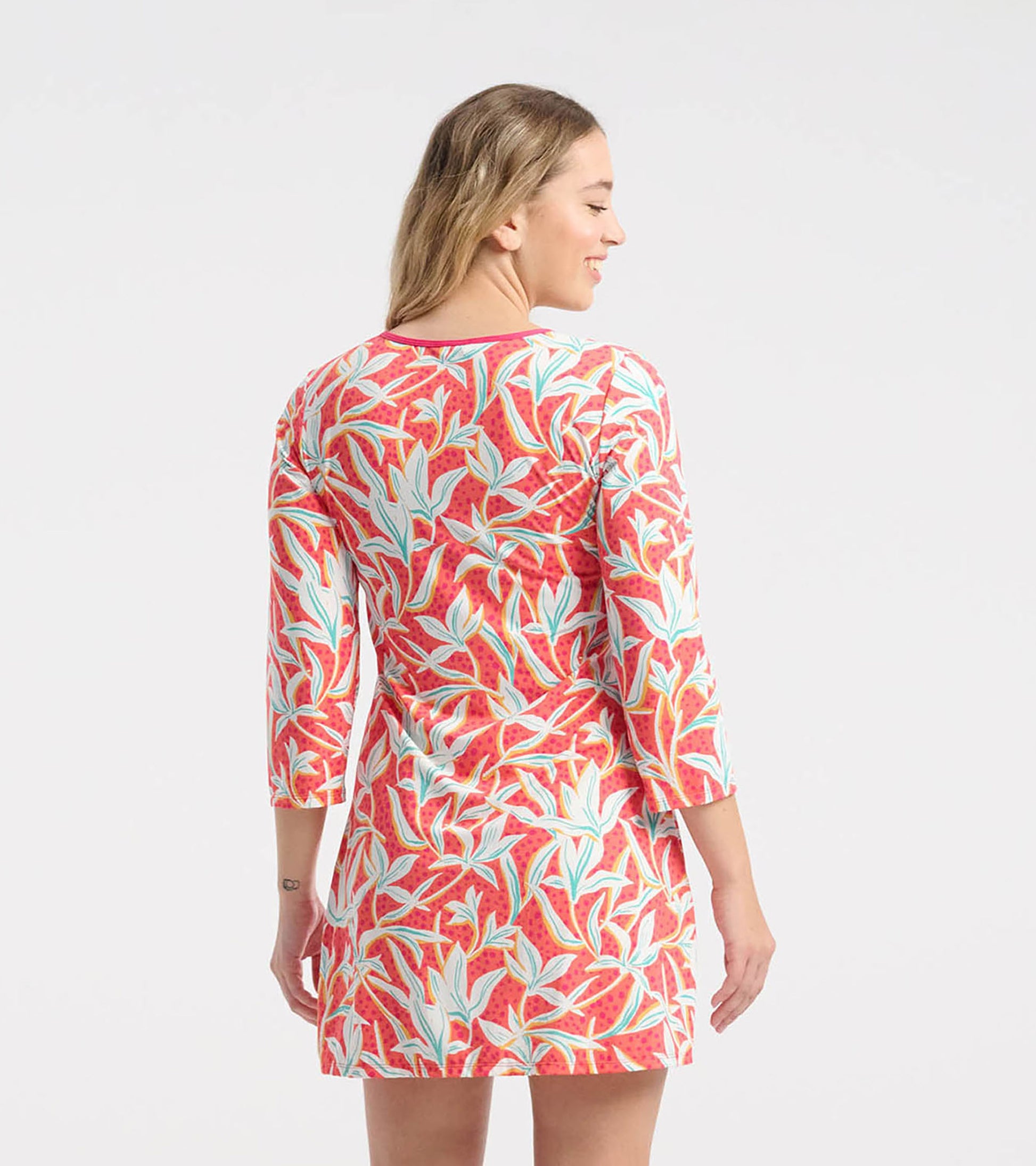 Red floral beach dress with three-quarter sleeves and a fitted silhouette, featuring a leafy pattern in blue and green.