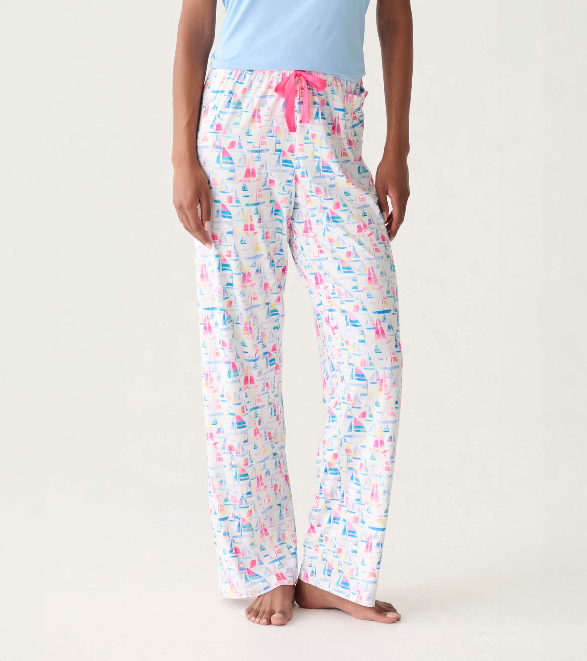 Women's white pajama pants with colorful sailboat print, pink drawstring waist, straight leg, front view