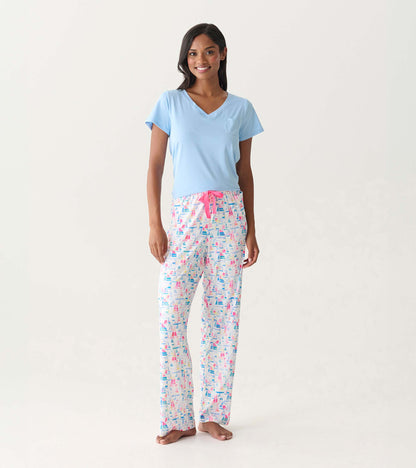 Women's pajama pants with colorful sailboat print, pink drawstring waist, shown on model.