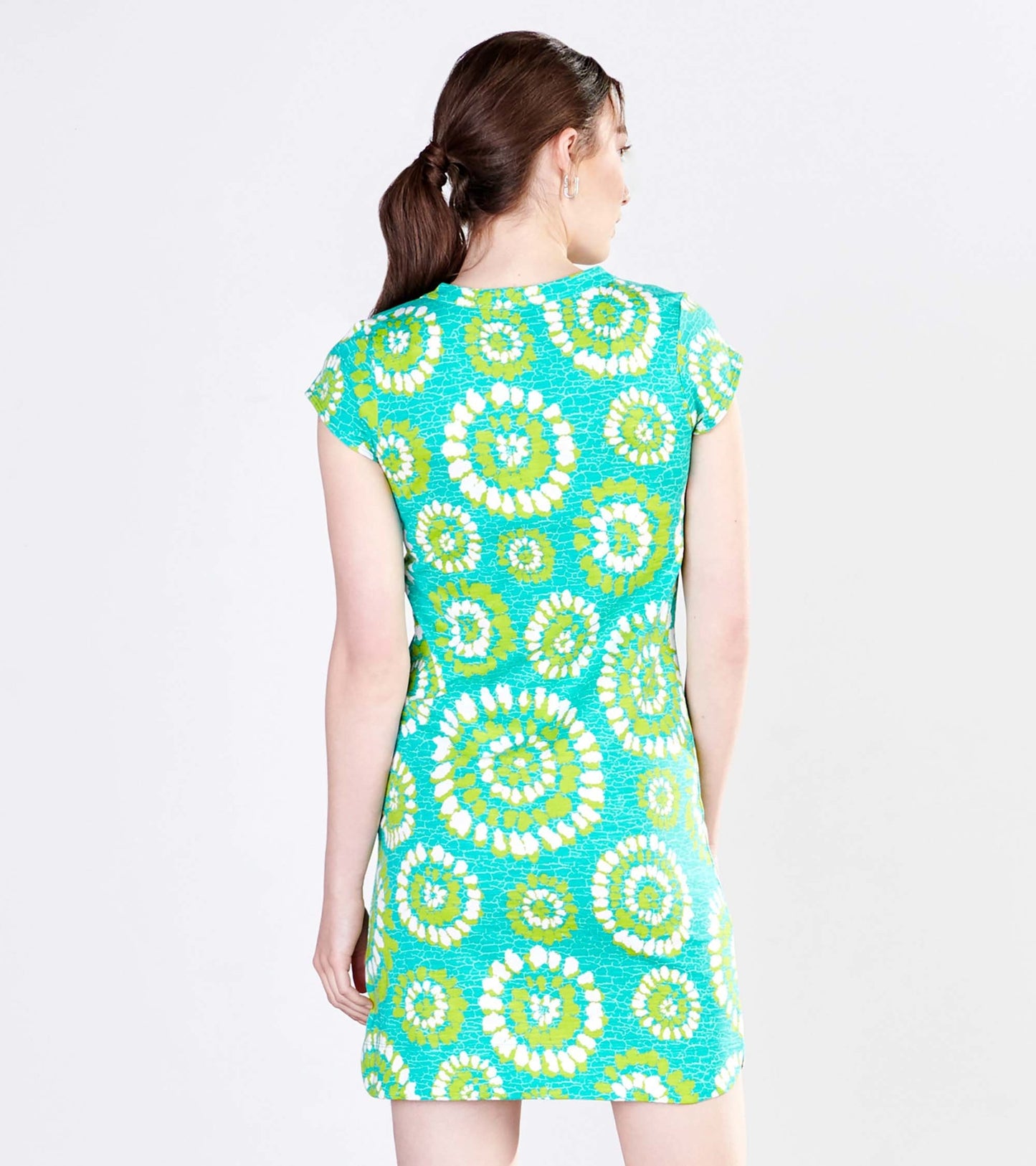 Short-sleeve dress featuring a vibrant turquoise fabric with a painted mandala pattern in green and white. Back view.