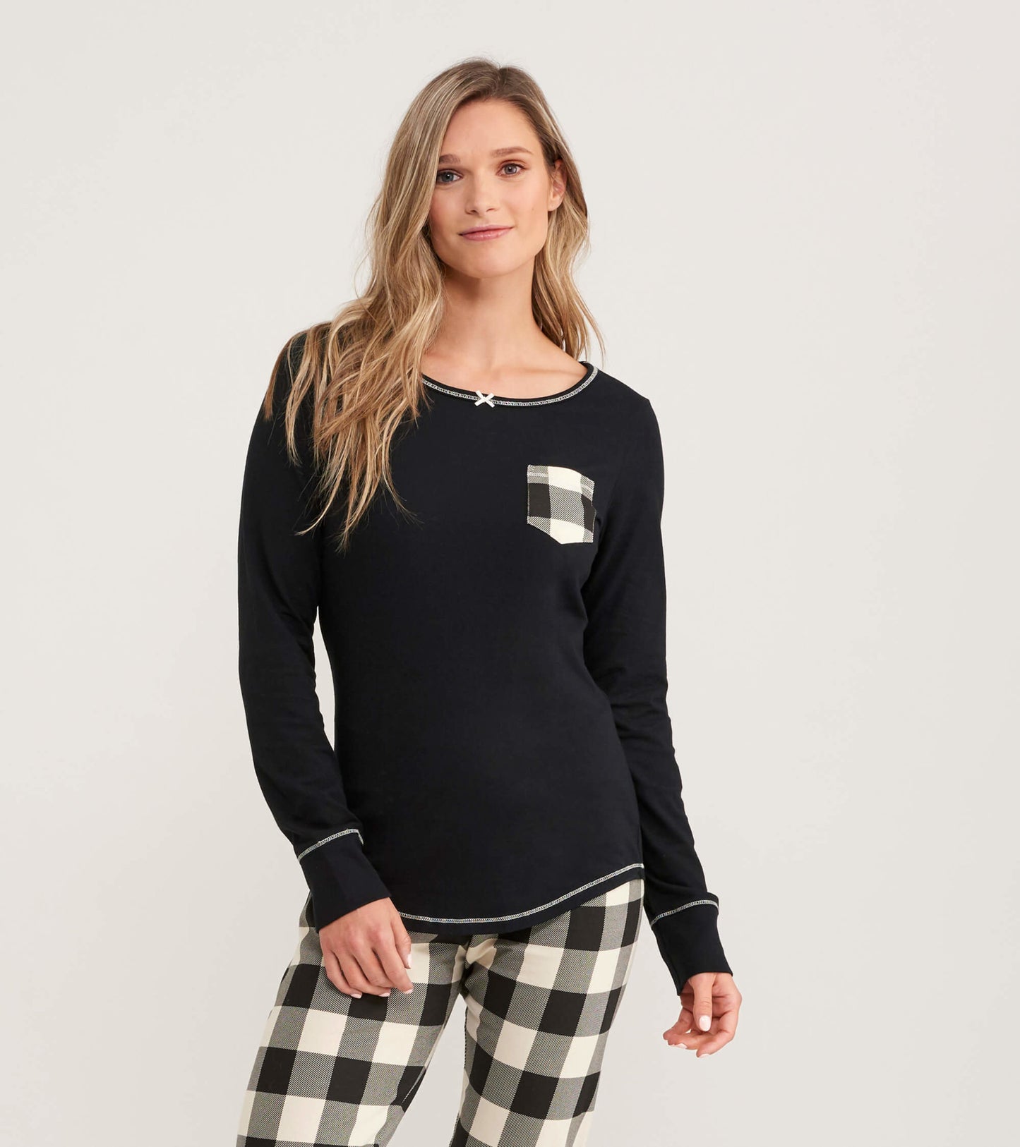 Black long-sleeve jersey top featuring a cream plaid pocket and contrasting stitching, ideal for casual wear.