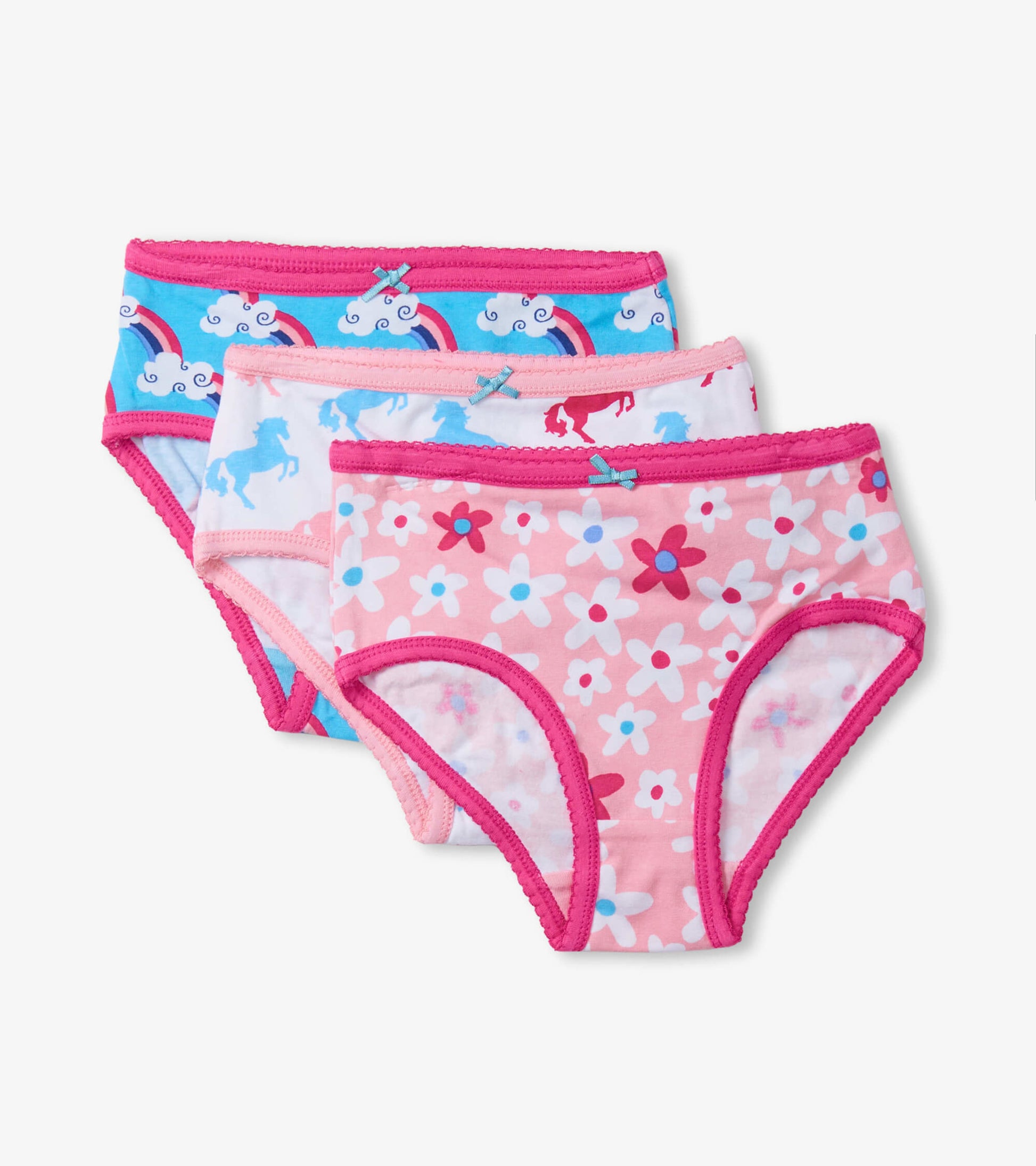 Three pairs of girls' brief underwear featuring colorful patterns: unicorns, rainbows, and flowers with pink trim.