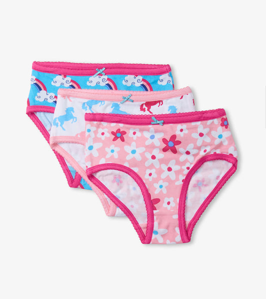 Three pairs of girls' brief underwear featuring colorful patterns: unicorns, rainbows, and flowers with pink trim.