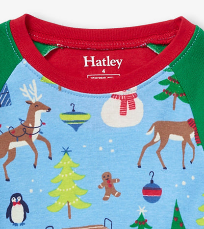 Blue organic cotton pajama set featuring festive holiday patterns, including reindeer, trees, and ornaments, with red and gr…