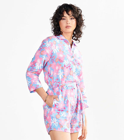 Colorful floral romper in pink and blue with a collared neckline, long sleeves, and a belted waist.