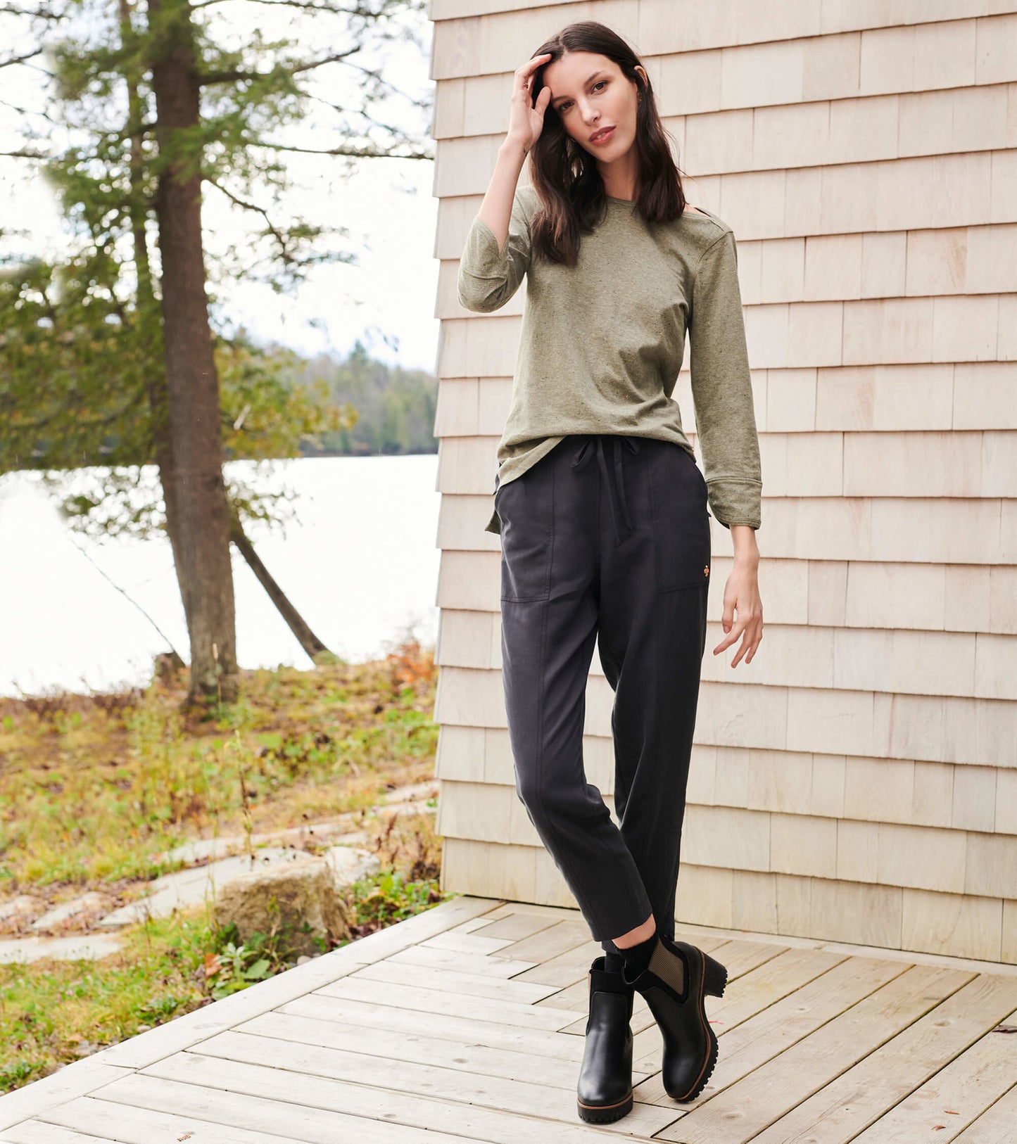 Loden green 3/4 sleeve Breton top, paired with dark pants and ankle boots, set against a natural outdoor backdrop.