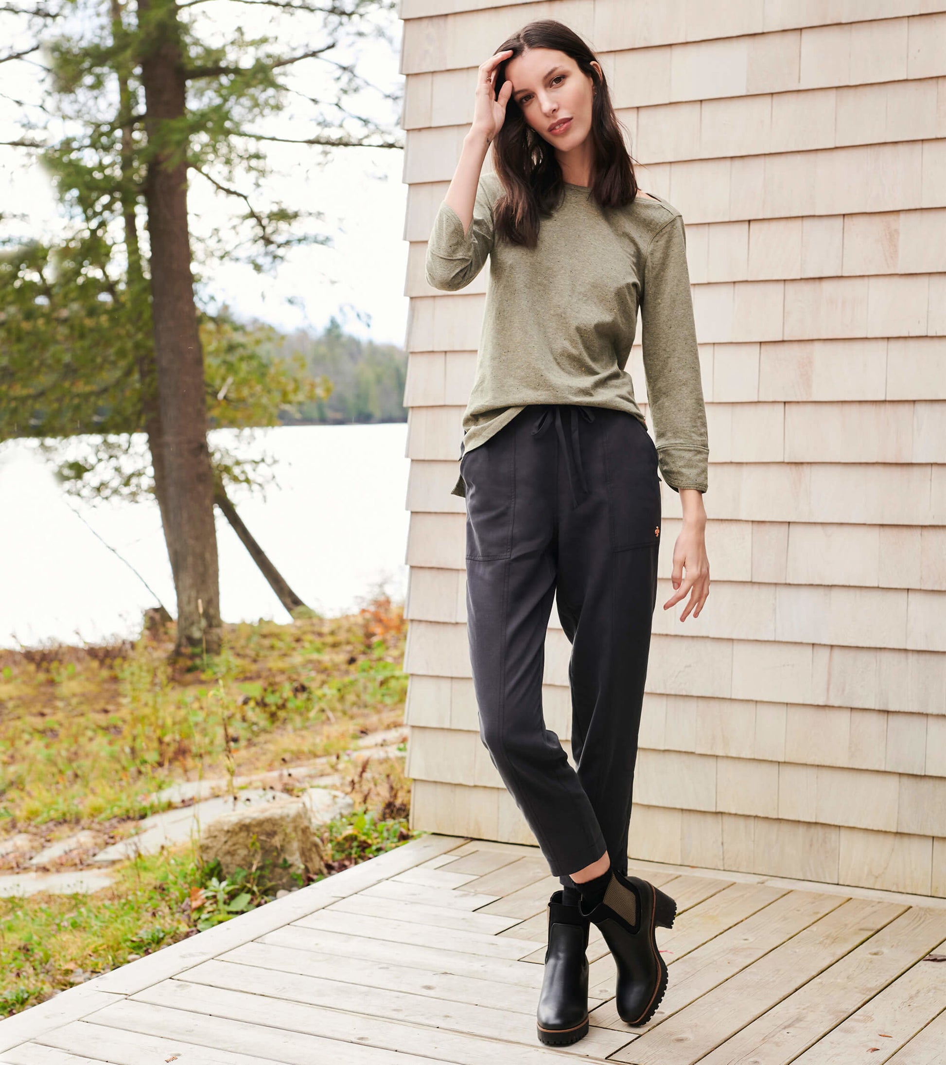 Loden green 3/4 sleeve Breton top, paired with dark pants and ankle boots, set against a natural outdoor backdrop.