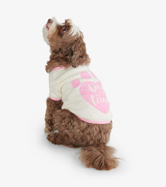Cream dog tee with pink accents and paw print design, featuring the text "Dog Tired," shown on a seated dog.