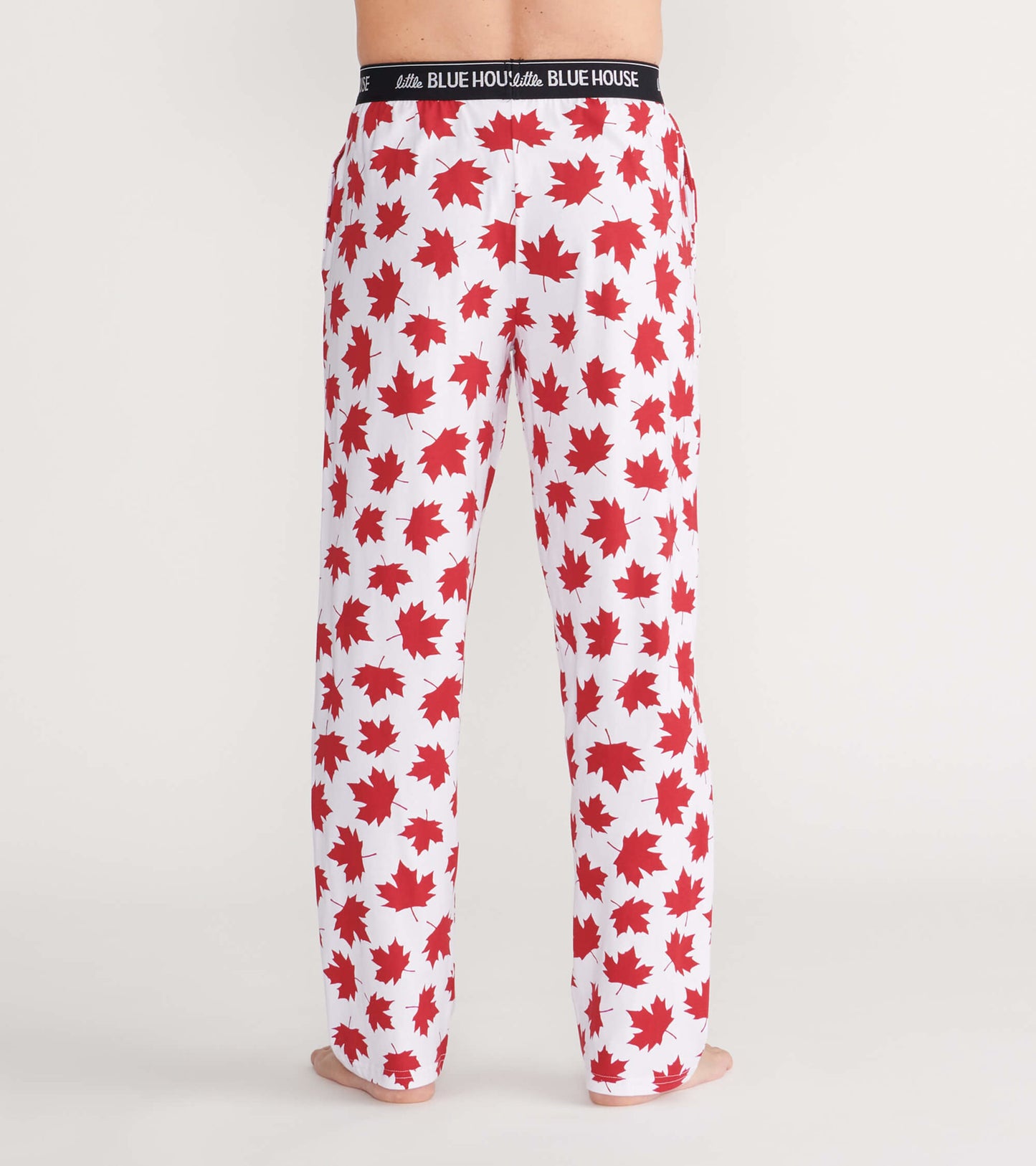 Men's pajama pants in white with a red maple leaf pattern, featuring an elastic waistband, shown from the back.