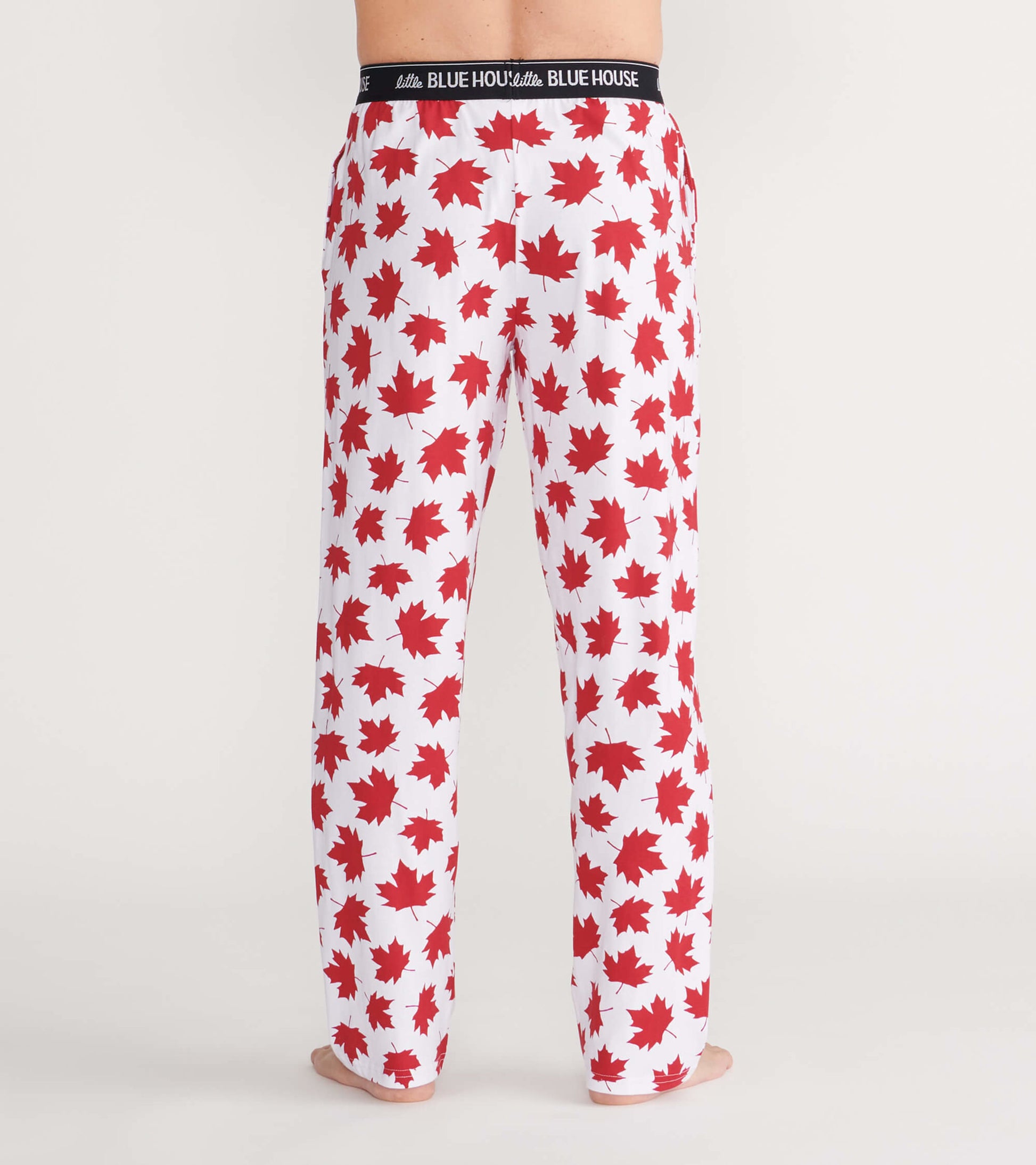 Men's pajama pants in white with a red maple leaf pattern, featuring an elastic waistband, shown from the back.