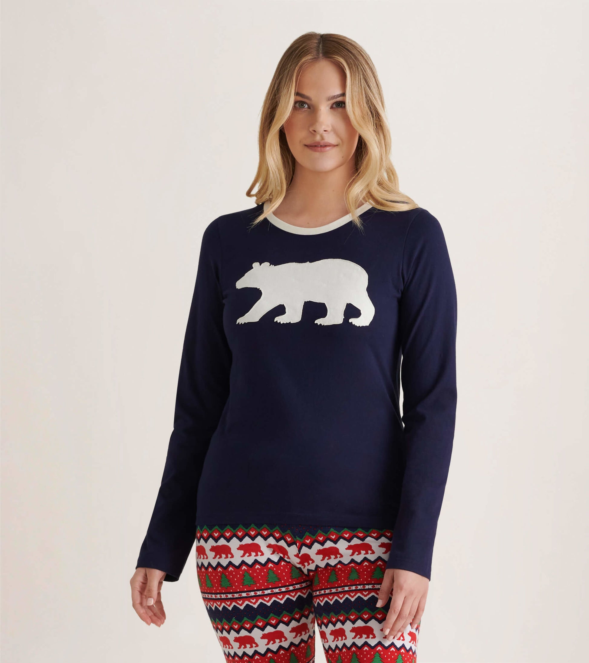 Navy long sleeve pajama top featuring a white polar bear graphic, paired with festive patterned pants.