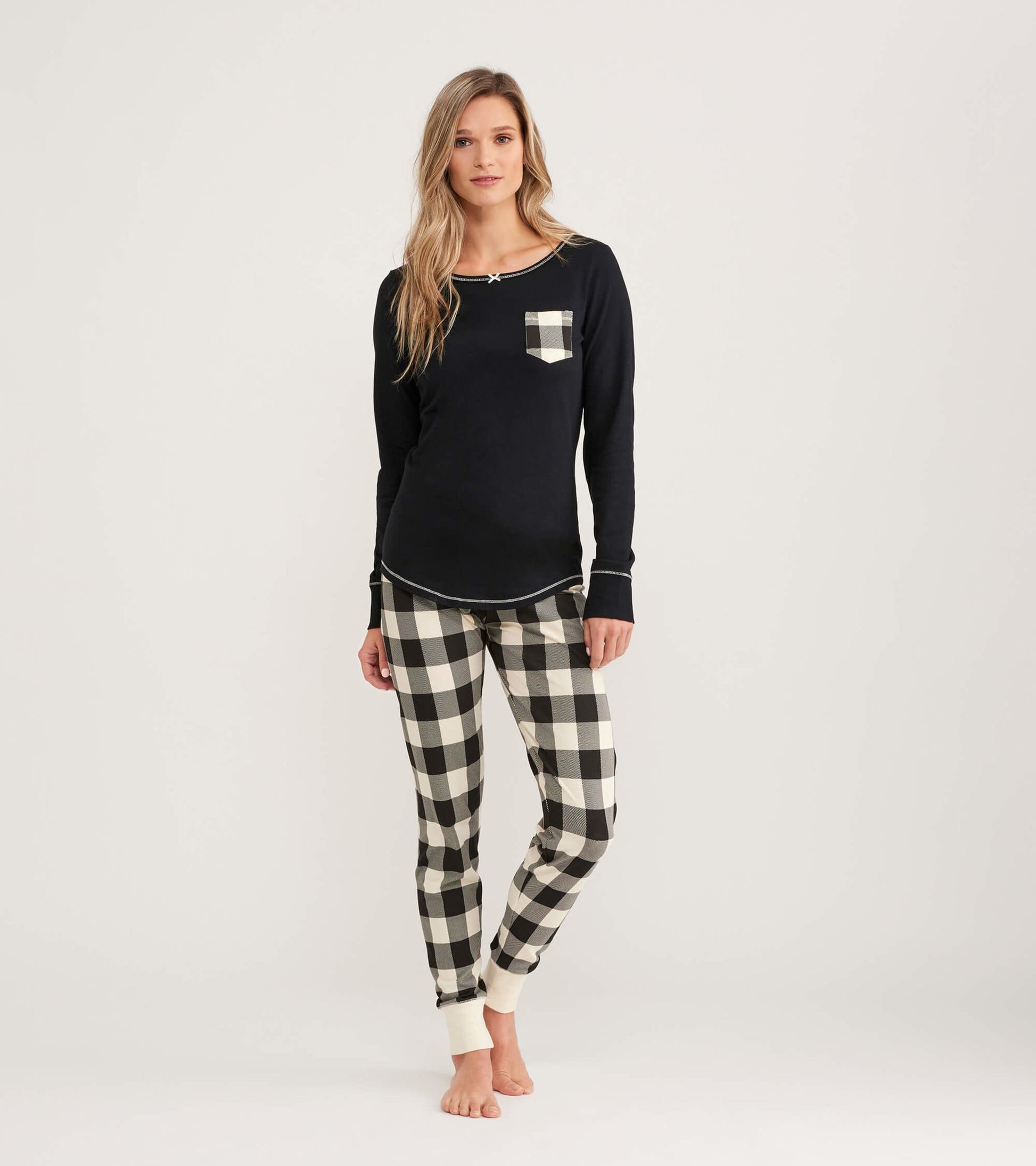 Black long-sleeve top with a plaid pocket, paired with black and cream plaid pants, suitable for casual wear.