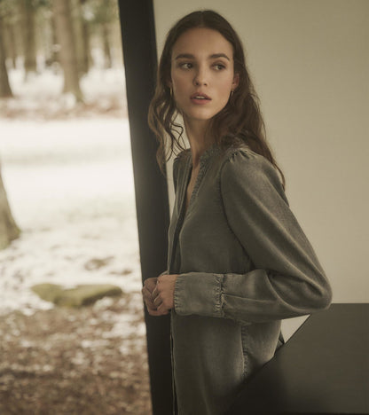 Black acid wash blouse with long sleeves and a relaxed fit, styled with a v-neckline.