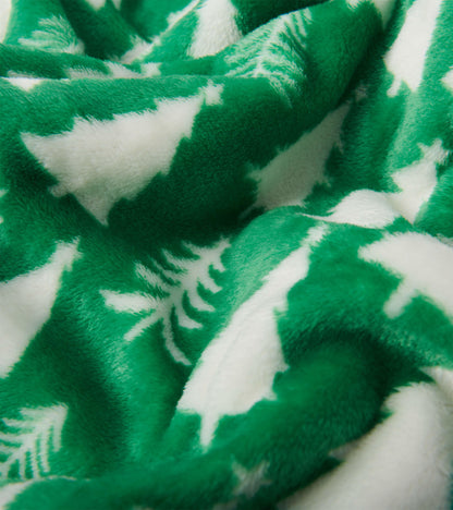 Green fleece blanket featuring white Christmas tree patterns, soft texture, ideal for cozying up during the holidays.