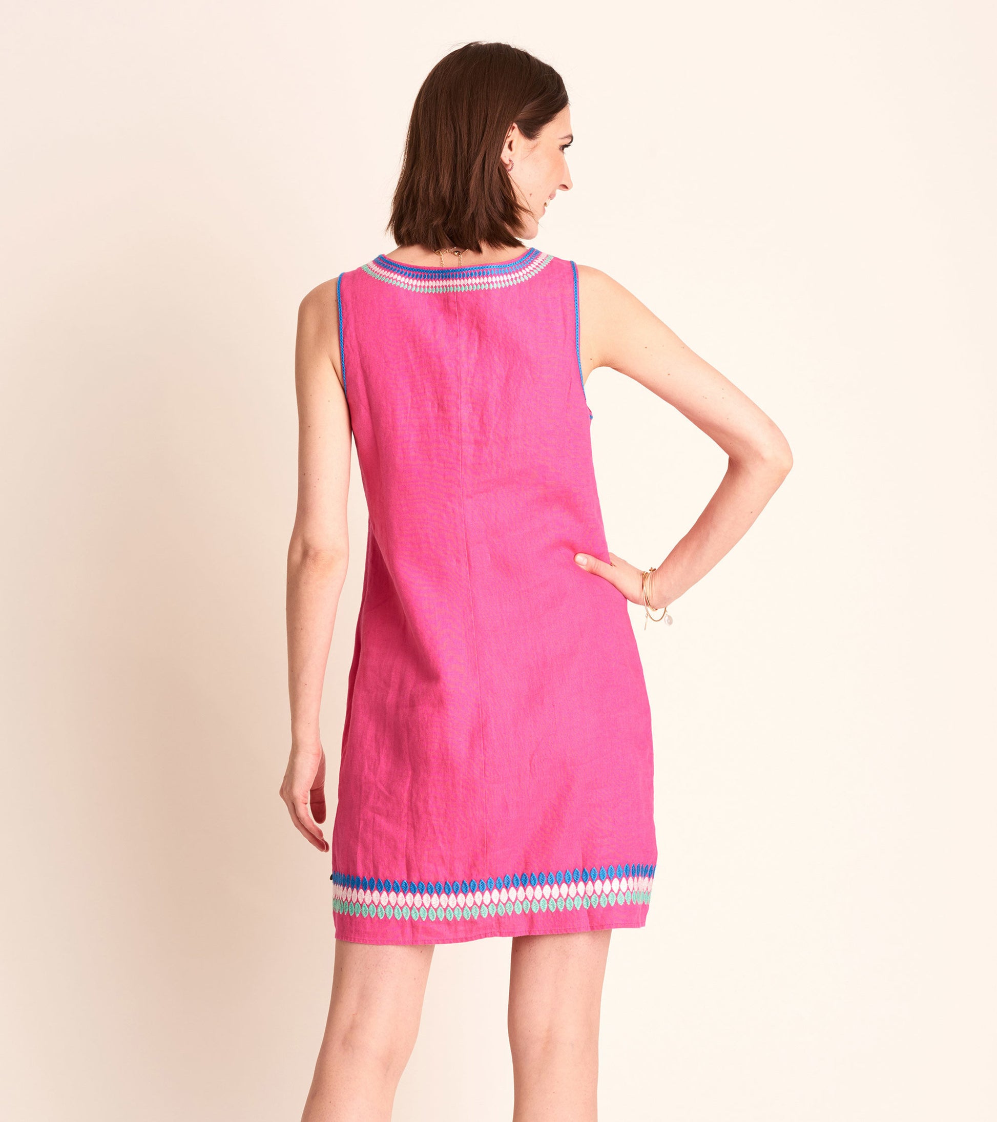 Fuchsia sheath dress with a colorful embroidered hem, sleeveless design, and a relaxed fit, shown from the back.