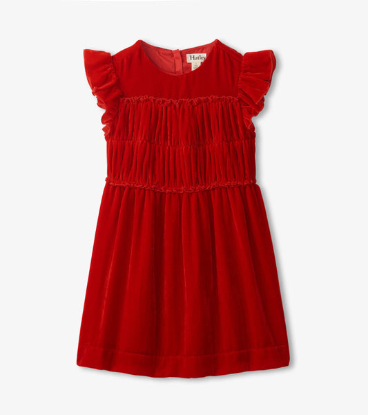 Red velvet dress featuring a smocked panel and ruffled sleeves, designed for girls.