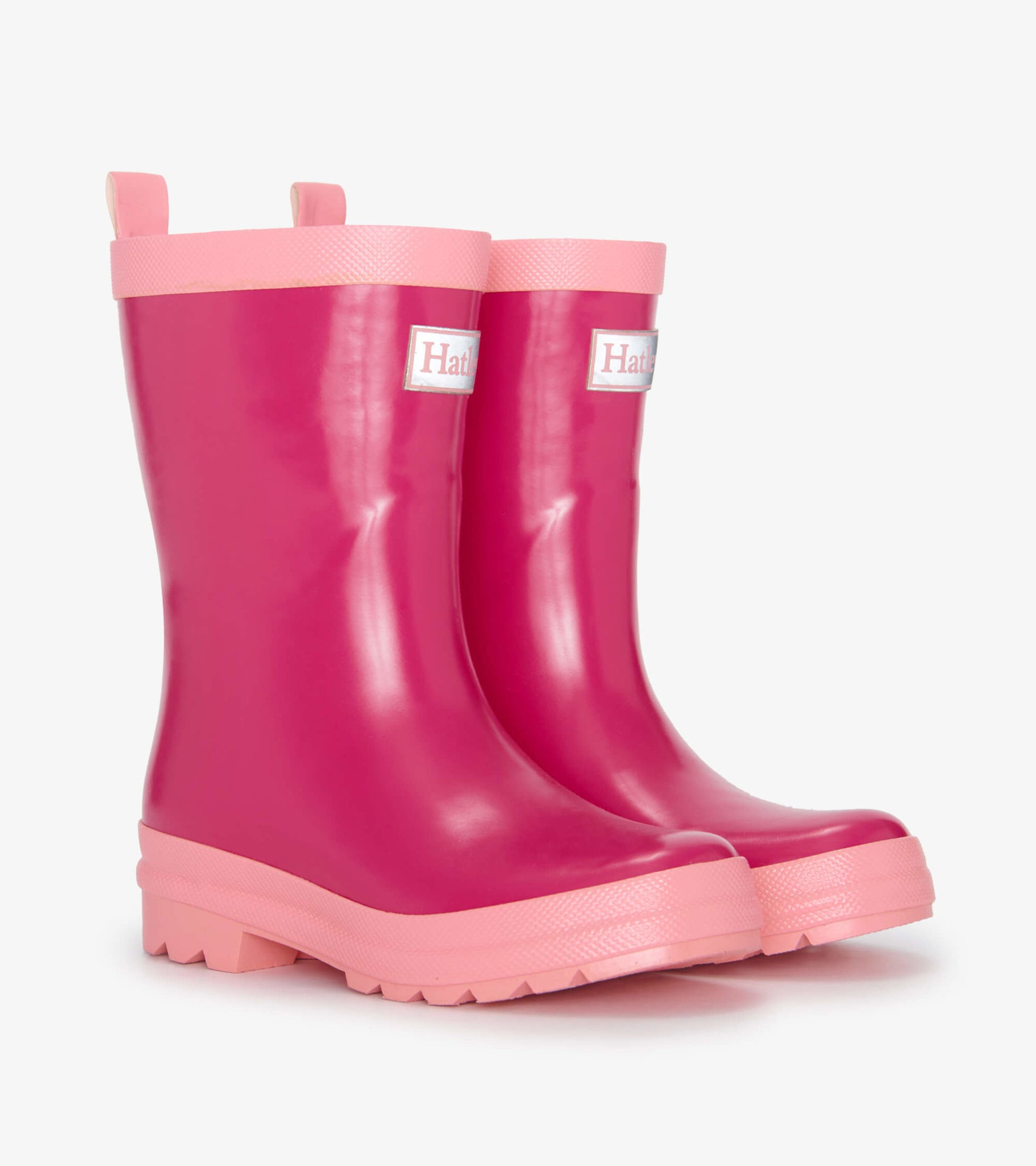 Pink shiny rain boots with a textured pink sole and pull tabs for easy wear. Suitable for kids.