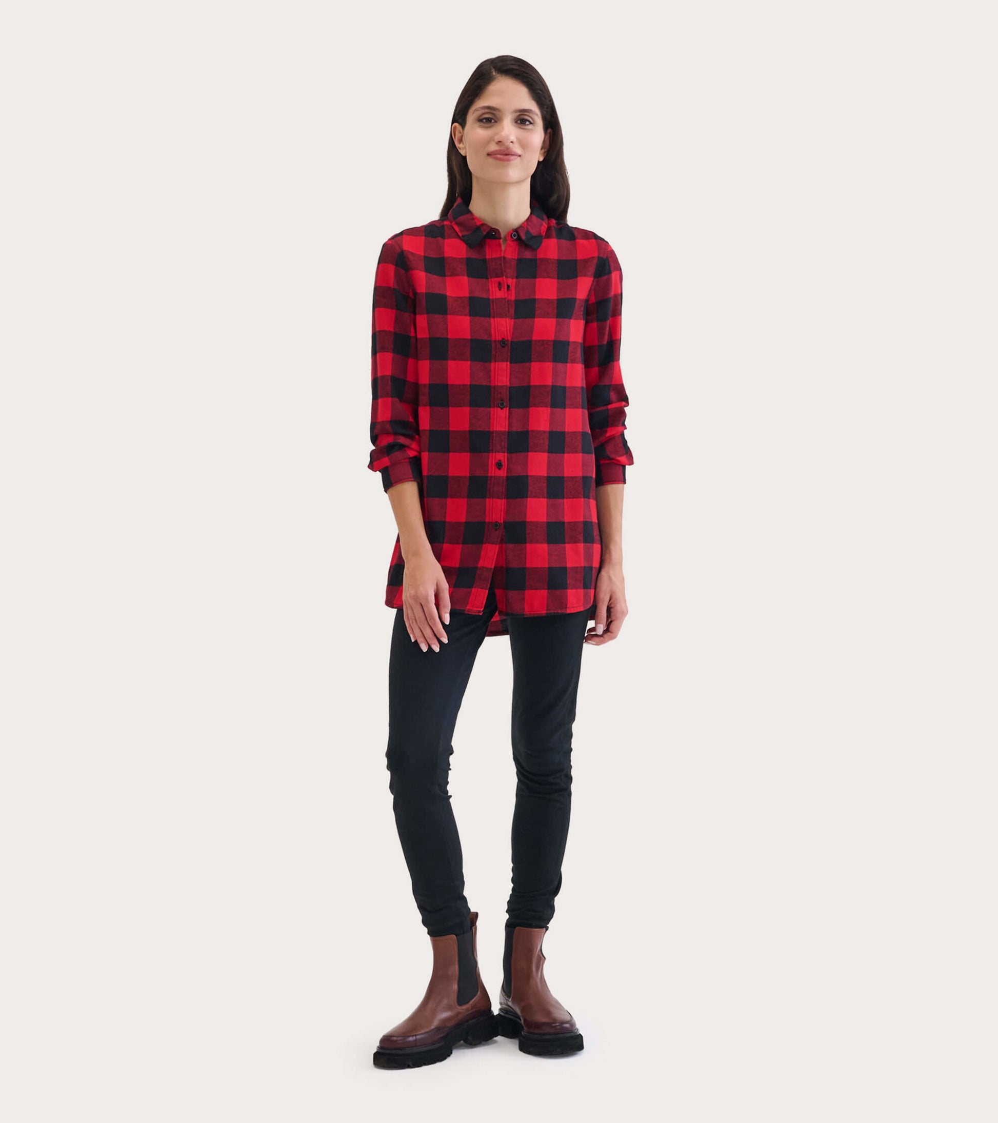 Red and black buffalo plaid flannel tunic with long sleeves and button closure, styled with black pants and boots.