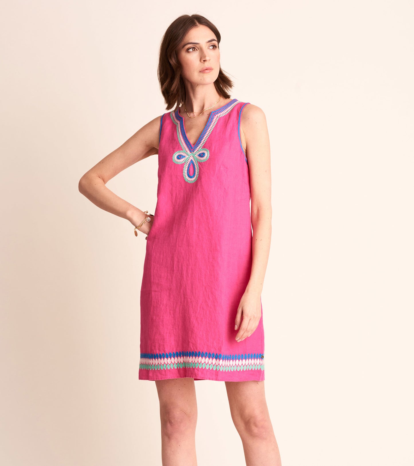 Fuchsia sheath dress with a V-neck and colorful embroidered detailing at the neckline and hem.