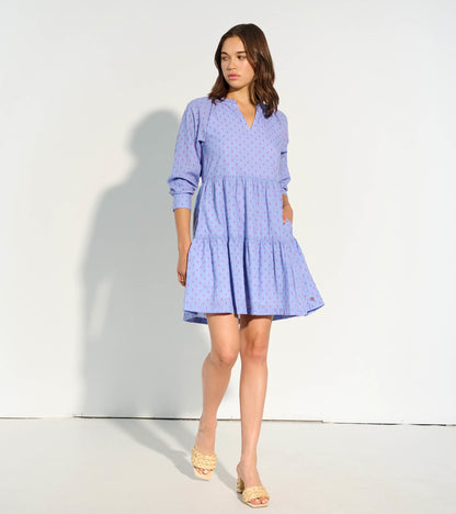 Pink clip dot dress with a tiered skirt and long sleeves, featuring a v-neckline and pockets.