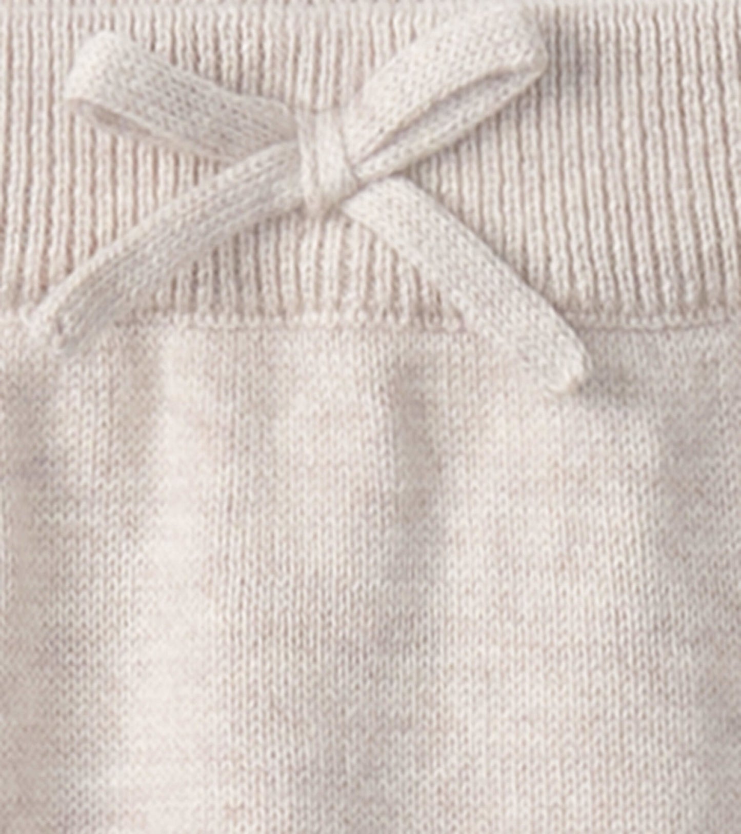 Light beige oatmeal sweater pants with a ribbed waistband and a decorative bow detail. Suitable for babies 0-9 months.