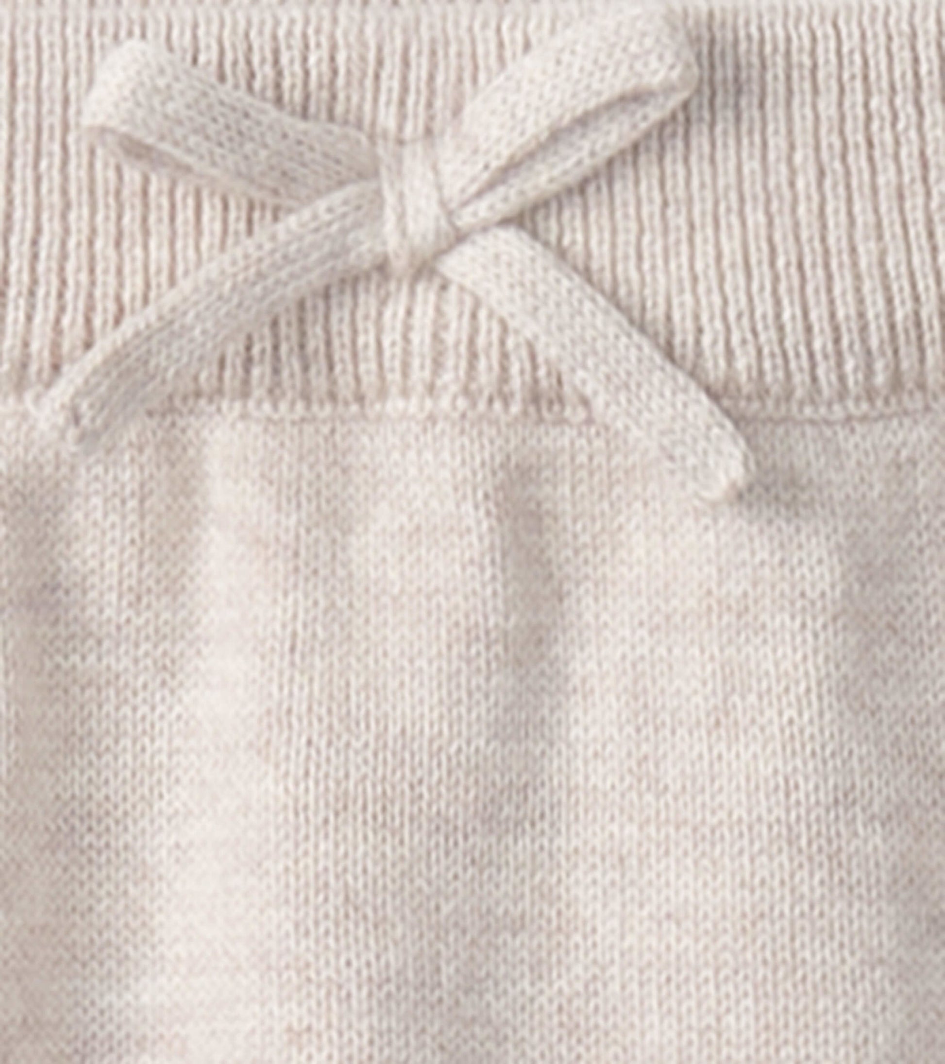 Light beige oatmeal sweater pants with a ribbed waistband and a decorative bow detail. Suitable for babies 0-9 months.