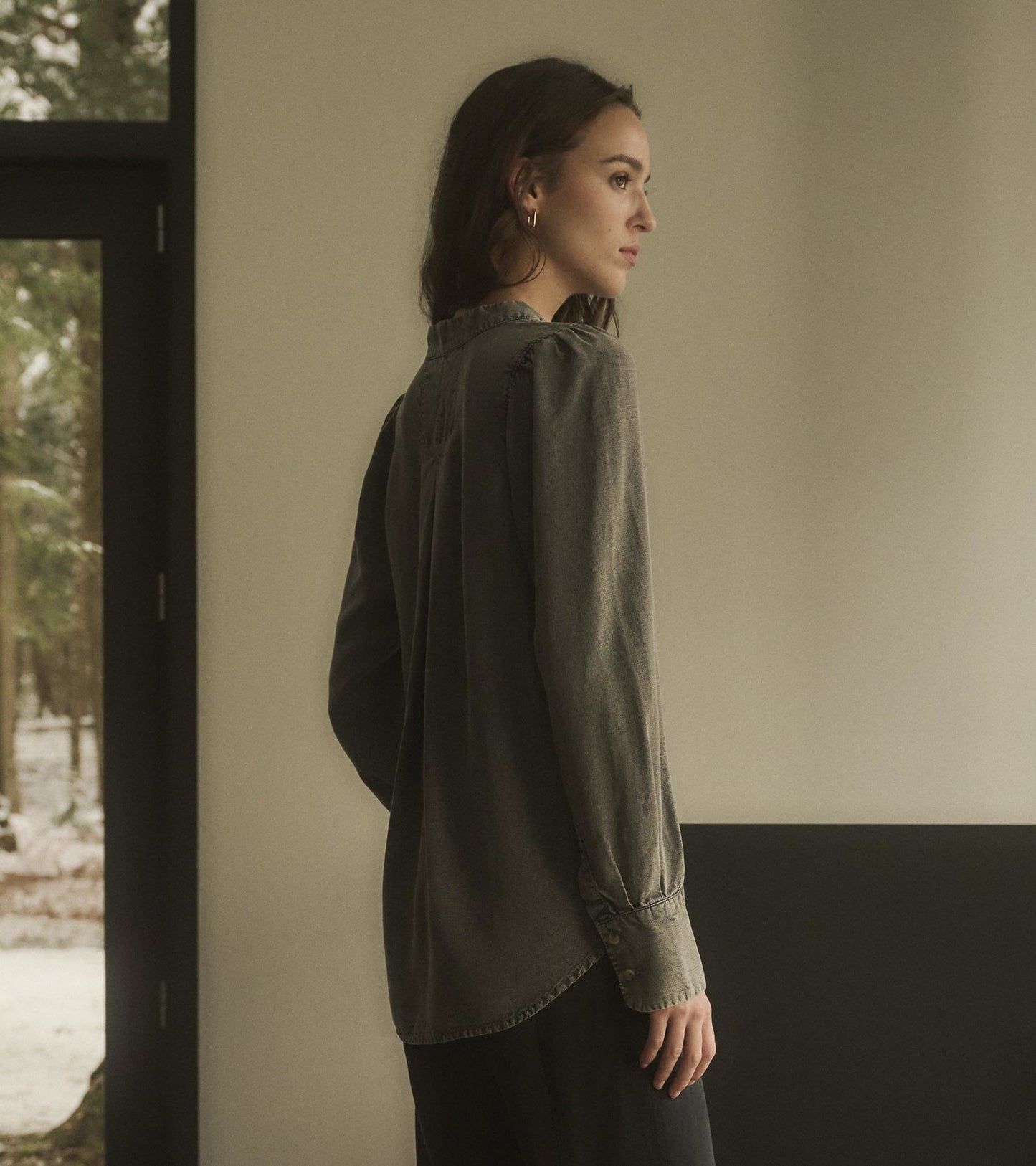 Black acid wash blouse with long sleeves and a relaxed fit, shown from the side against a neutral background.