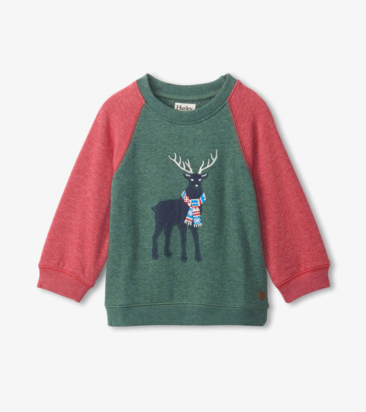 Green pullover sweatshirt with red sleeves featuring a black stag wearing a colorful scarf.