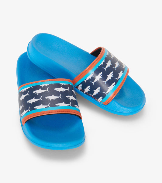 Blue slide sandals featuring a shark print strap with orange and turquoise accents. Ideal for casual wear.
