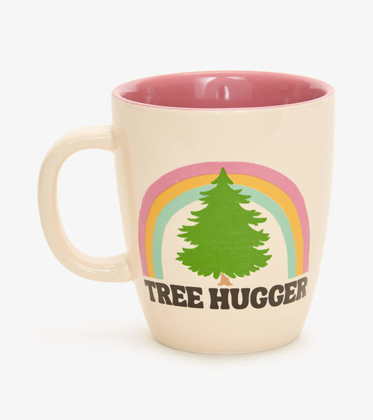 Cream ceramic mug with a pink interior, featuring a tree graphic and "TREE HUGGER" text beneath a rainbow design.