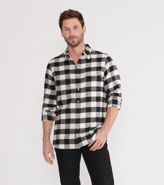 Black and cream plaid flannel shirt with long sleeves and two chest pockets, styled casually.