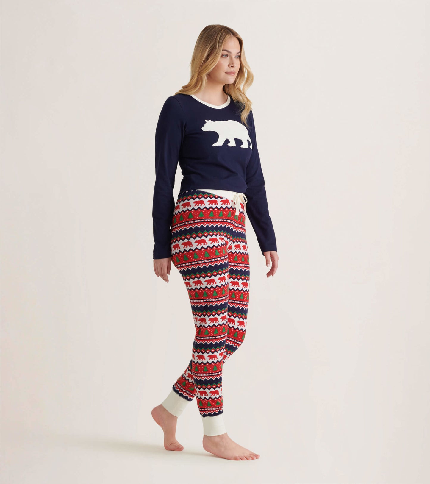 Navy long sleeve pajama top with white polar bear graphic, paired with festive patterned pants in red, white, and blue.