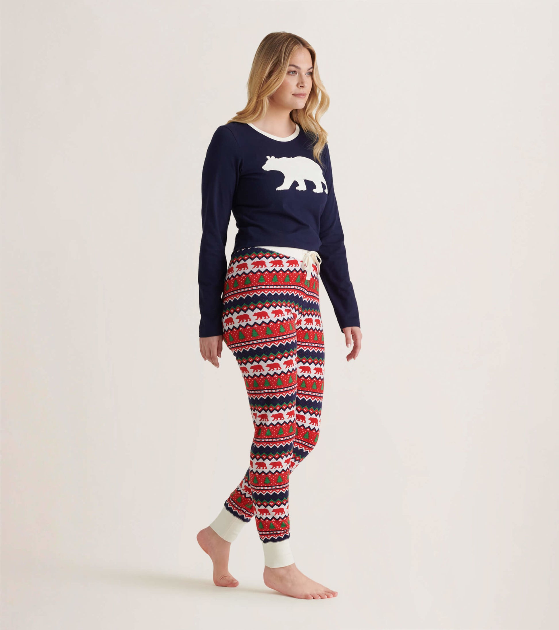 Navy long sleeve pajama top with white polar bear graphic, paired with festive patterned pants in red, white, and blue.