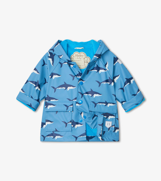 Blue baby raincoat featuring a shark pattern, with a soft inner lining and front pockets. Suitable for wet weather.