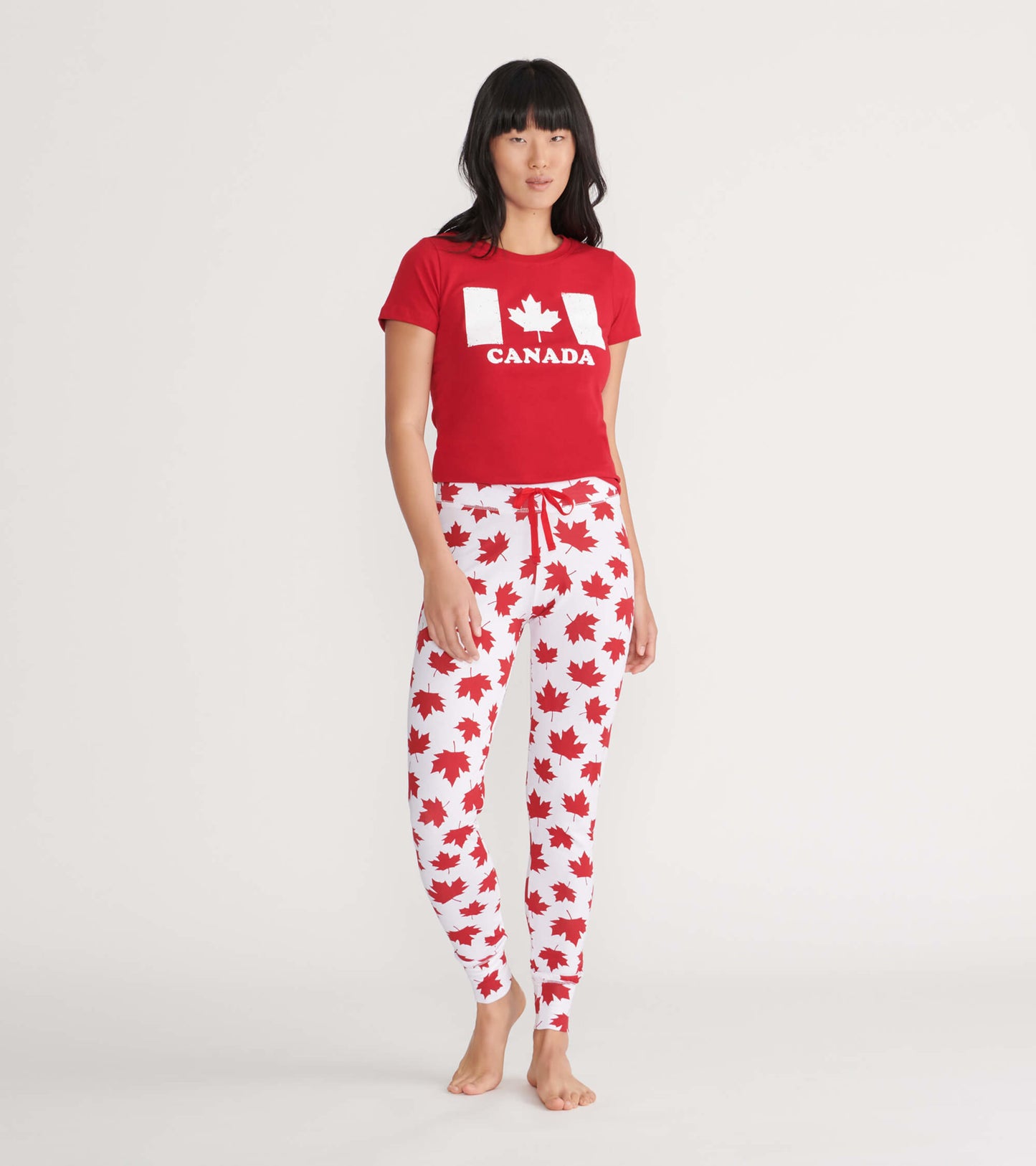 Red short-sleeve tee featuring a white Canada graphic, paired with white pants adorned with red maple leaf patterns.