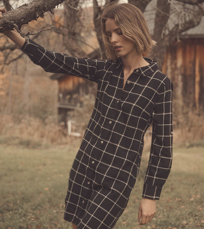 Black windowpane shirt dress with long sleeves and button front, styled in an outdoor setting.