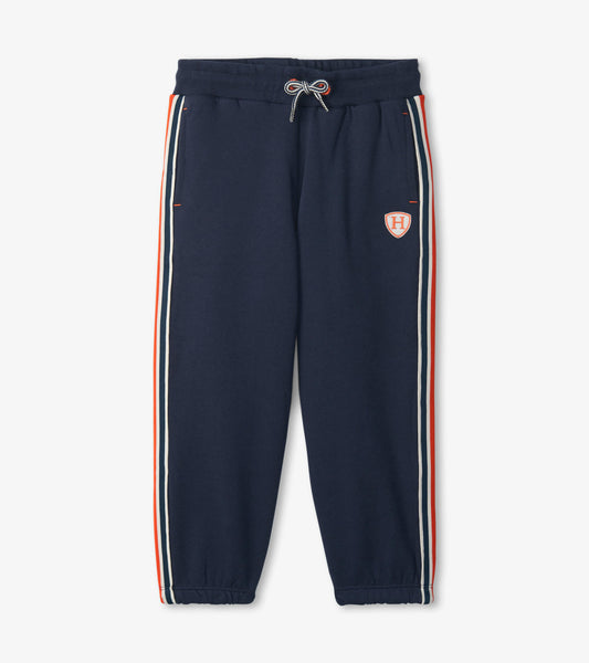 Navy relaxed joggers with side stripes in red and white, featuring an elastic waistband and cuffed ankles.