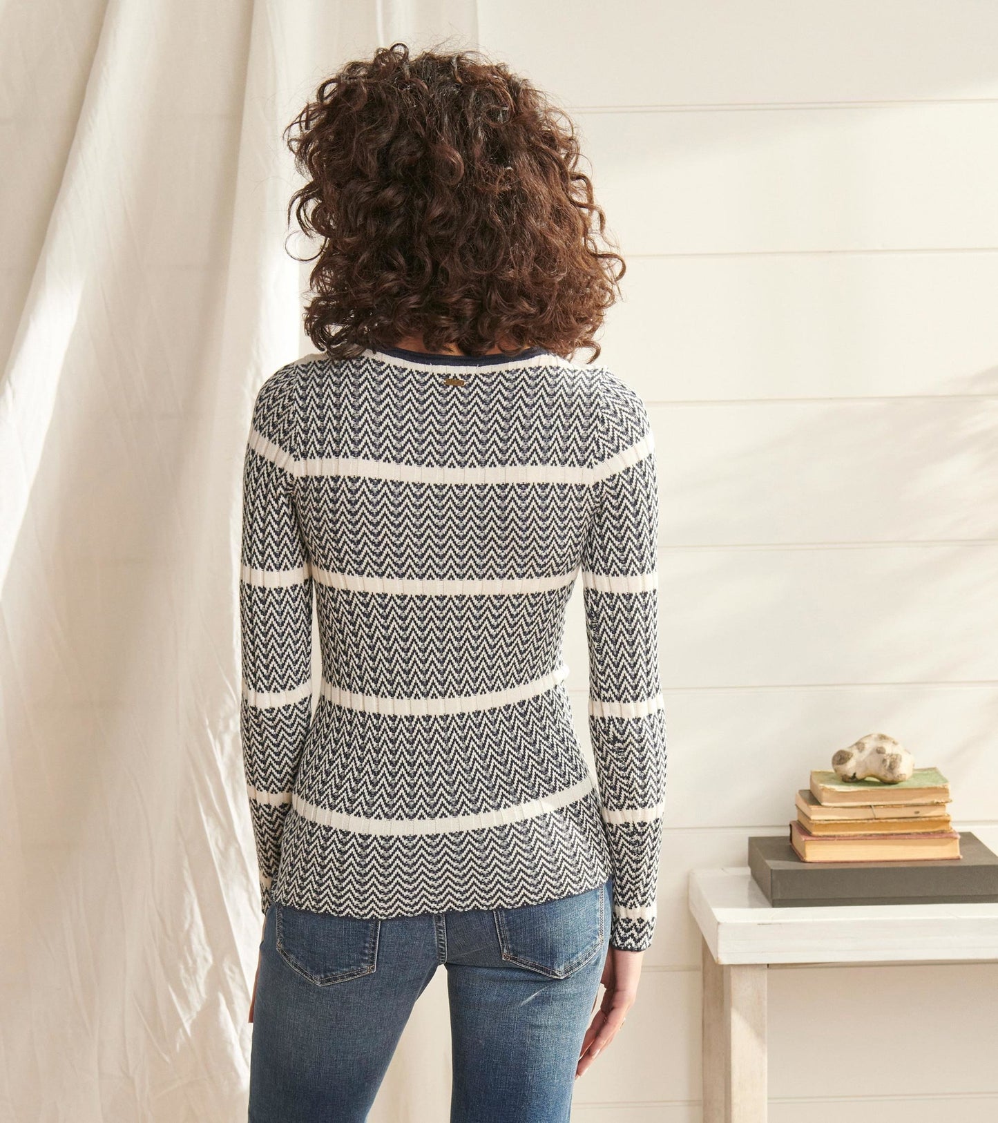 Navy and white zigzag patterned sweater with long sleeves, fitted shape, and crew neckline, viewed from the back.