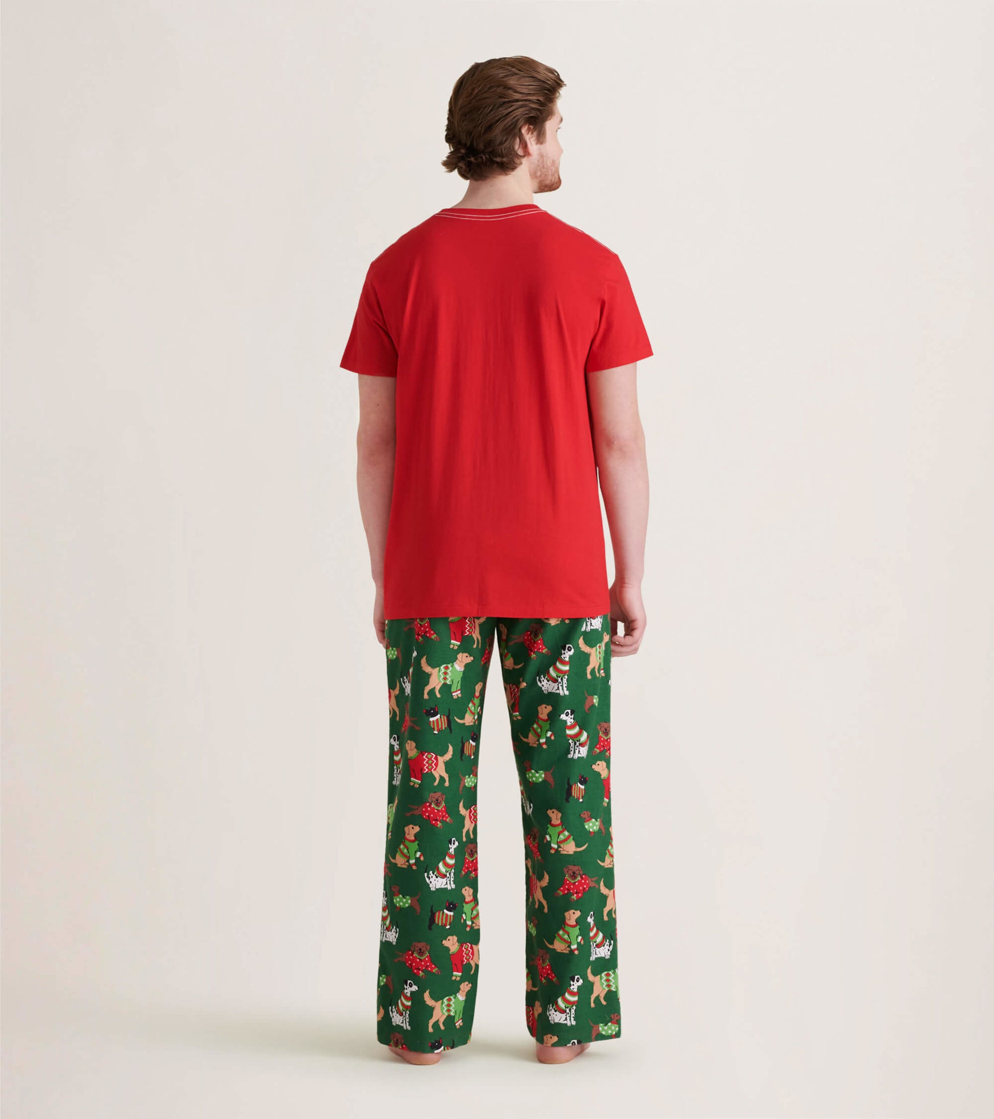 Green flannel pajama pants featuring a festive dog and floral pattern, paired with a red short-sleeve shirt.