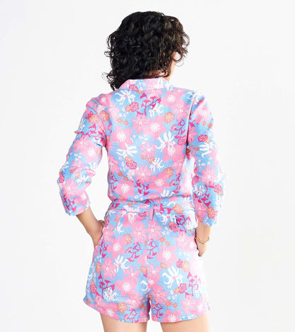 Back view of a pink floral romper with short sleeves and a cinched waist, featuring a vibrant wildflower pattern.